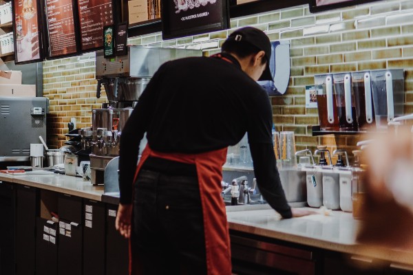 man working behind the counter at a cafe