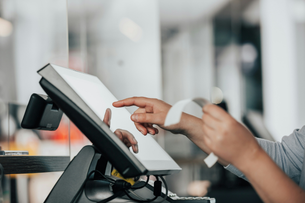 Business owner holding receipt and touching computer screen